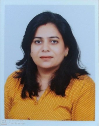 Portrait of Dr. Kapoor wearing traditional attire with academic books in background